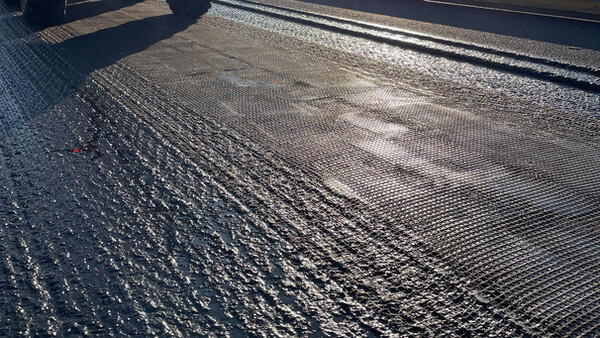 Verlegen der S&P Asphaltbewehrung beim Projekt "Charge As You Drive" 